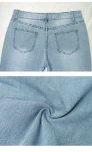 Detail of light blue straight-leg denim jeans showing back pockets and twill fabric texture