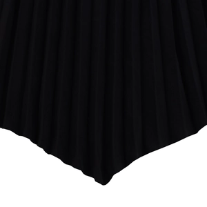 Detail view of black pleated dress featuring elegant handkerchief hem and premium fabric