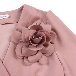 Detail of V-neck collar featuring a 3D fabric flower on elegant pink pleated dress
