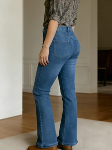 Women's high waist flared jeans in mid-blue denim with a slimming stretch fit back view