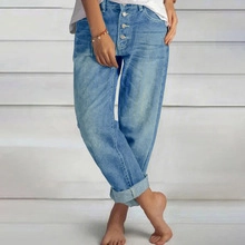 Detail view of high waisted light blue denim jeans with metal button fly and cuffed hems