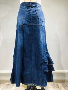 Dettaglio della gonna lunga in denim blu con balze a strati e cuciture sulle tasche