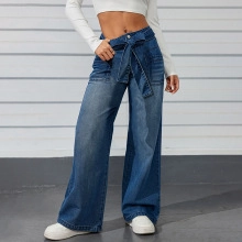 Detail of high waist dark denim shorts with bow-tie waist belt and wide-leg cut