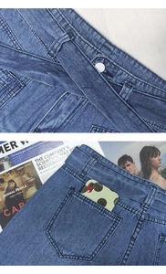 Detailed macro view of denim jeans waistline with metal button and matching fabric belt