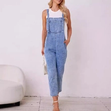 Detail of light blue acid wash denim overalls with adjustable straps and large front pocket
