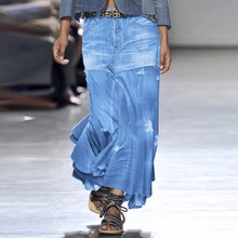 Detail of light wash denim skirt with frayed irregular hem and stylish leather belt