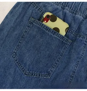 Vue détaillée de la taille élastique et de la poche arrière sur jupe longue en jean
