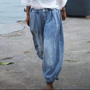 Détail d'un pantalon sarouel en jean pour femme avec taille élastique et bouton de fermeture