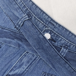 Elegant wide-leg blue denim trousers featuring a decorative belt and white button detail