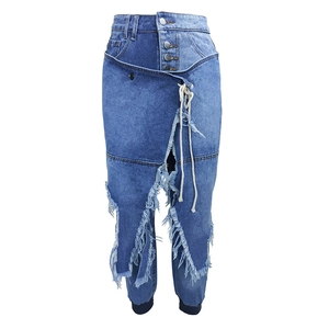High-waisted washed blue denim jeans with asymmetric layered design and distressed fringe hem