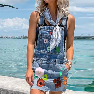 Vue détaillée de l'imprimé floral sur une robe salopette en jean avec ourlet effiloché