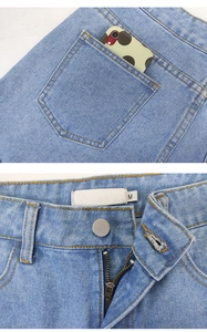 Detail of light blue denim shorts showing the back pocket capacity and waist button closure