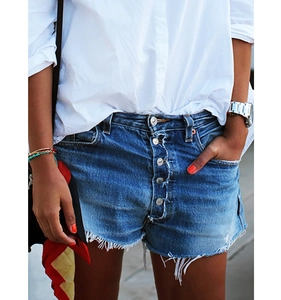 Détail du short en jean taille haute avec patte de boutonnage et bords effilochés