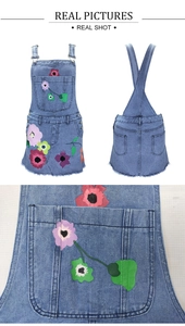 Détail de la robe chasuble en jean avec imprimé fleuri et ourlet effiloché