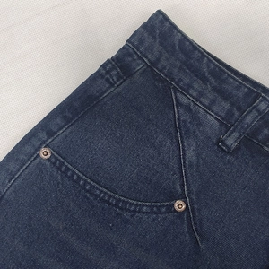 Deep blue denim straight jeans featuring classic side pockets and metal rivet details