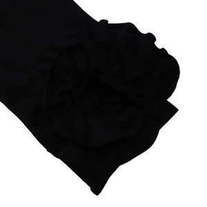 Detailed view of layered 3D flower ruffles and black fabric on the elegant long sleeve dress