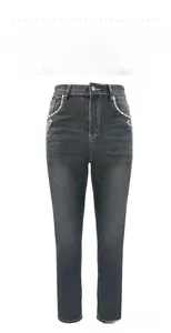 Detail of skull embroidery and rhinestone on the pocket of smoky grey stretch denim jeans