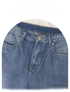 Close-up of classic blue washed denim waist with metal button and durable stitching