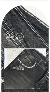 Detailed view of stretch denim fabric with skull embroidery and rhinestone pocket accents