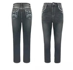 Detail view of denim jeans featuring skull and wing embroidery with sparkling rhinestones