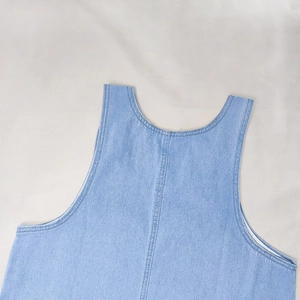 Close-up of light blue denim dress neckline with double stitching and washed texture