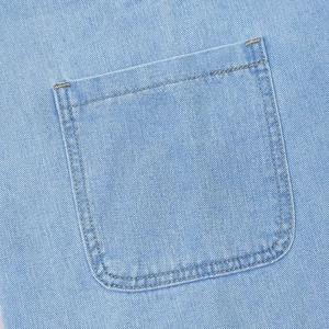Macro detail of denim fabric with orange contrast stitching on square back pocket