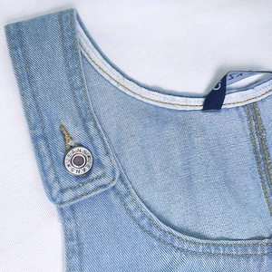 Light blue denim suspender dress with metallic jeans buttons and white contrast stitching