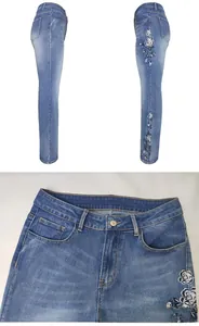 Detail of floral embroidery on high-waisted flared jeans with vintage blue wash