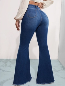 Dettaglio dei jeans a zampa a vita alta con orlo a taglio vivo e denim blu lavato