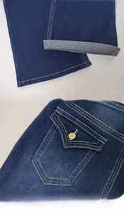 Close-up of dark blue flare jeans showing hem details and flap back pockets with stitching