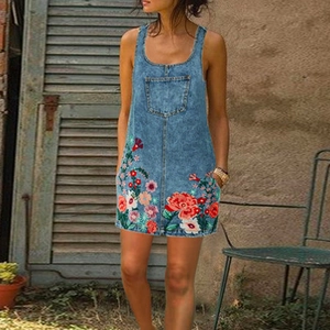 Detail of colorful floral embroidery on the hem of a dark blue denim sleeveless dress