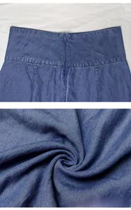 Detail of high waist dark blue denim skirt showing invisible zipper and twill fabric texture