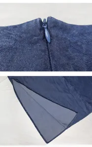 Detail view of high-waist denim skirt featuring hidden zipper and side slit stitching