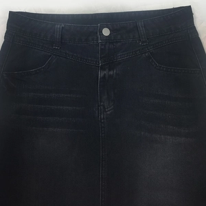 Détail de la taille du denim noir avec effet délavé et bouton en métal gris mat