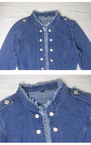 Detailed macro view of denim jacket showing raw fringe edges, metal buttons and shoulder epaulets