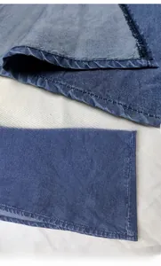 Detailed macro view of dark blue denim fabric with precise double stitching and washed texture