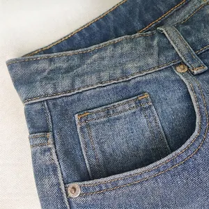Close-up of blue straight-leg denim jeans showing pocket details and copper rivets
