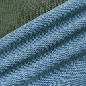 Detailed close-up of light blue and dark olive twill denim fabric texture comparison