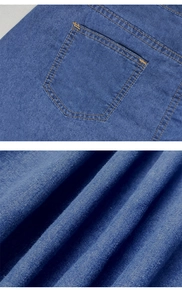 Detailed macro view of heavy denim fabric texture and orange contrast stitching on pockets