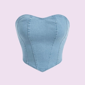 Dettaglio del corsetto in denim azzurro con scollo a cuore e fondo a punta a V