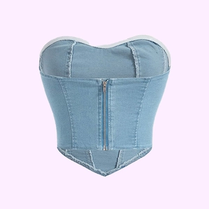 Dettaglio del top a fascia in denim celeste con cuciture a contrasto e zip frontale