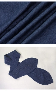 Detail der dunkelblauen Denim-Textur und weißen konzentrischen Nähten am Taillengürtel