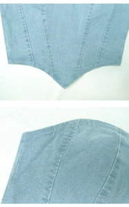 Dettaglio del top a fascia in denim azzurro con cuciture a stecche e fondo a punta