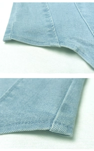 Dettaglio del tessuto denim blu chiaro con cuciture precise e manifattura di alta qualità
