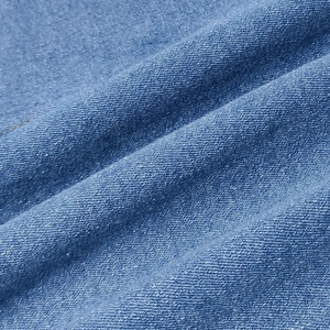 Close-up of blue denim fabric showing detailed twill texture and soft washed finish