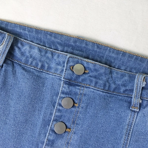 Detail of high-waist denim skirt showing three metal buttons and yellow contrast stitching