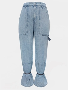 Detail of light blue denim cargo pants showing large utility pockets and gathered hem design