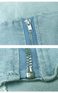 Dettaglio della cerniera in metallo SBS sul tessuto denim azzurro del top a fascia