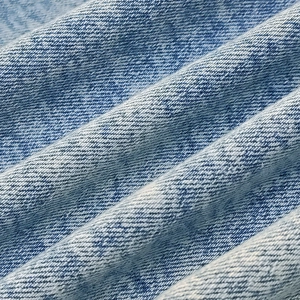 Macro view of light blue denim fabric texture and twill weave pattern on jacket