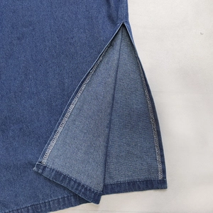Dettaglio dello spacco laterale su abito in denim blu scuro con cuciture a contrasto